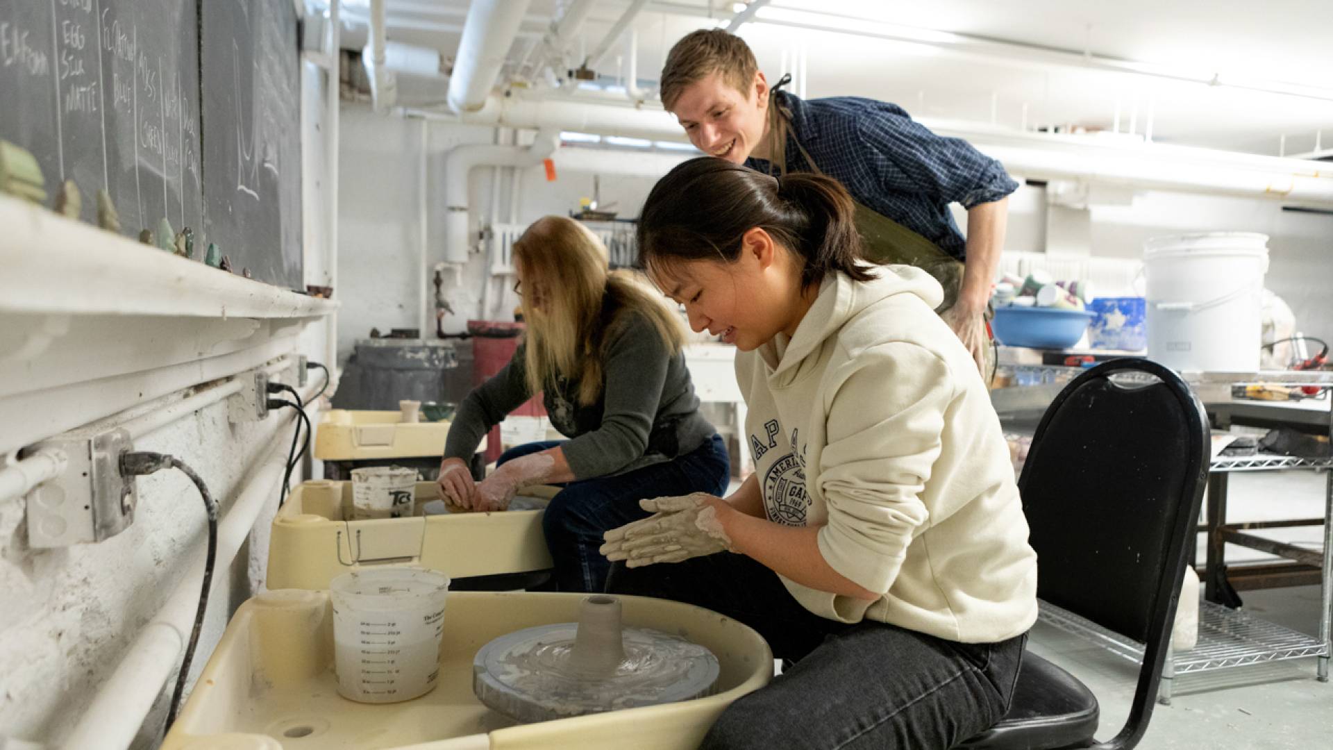 Students and staff learn to spin clay during a Wintersession pottery class held at the Lewis Center for the Arts.
