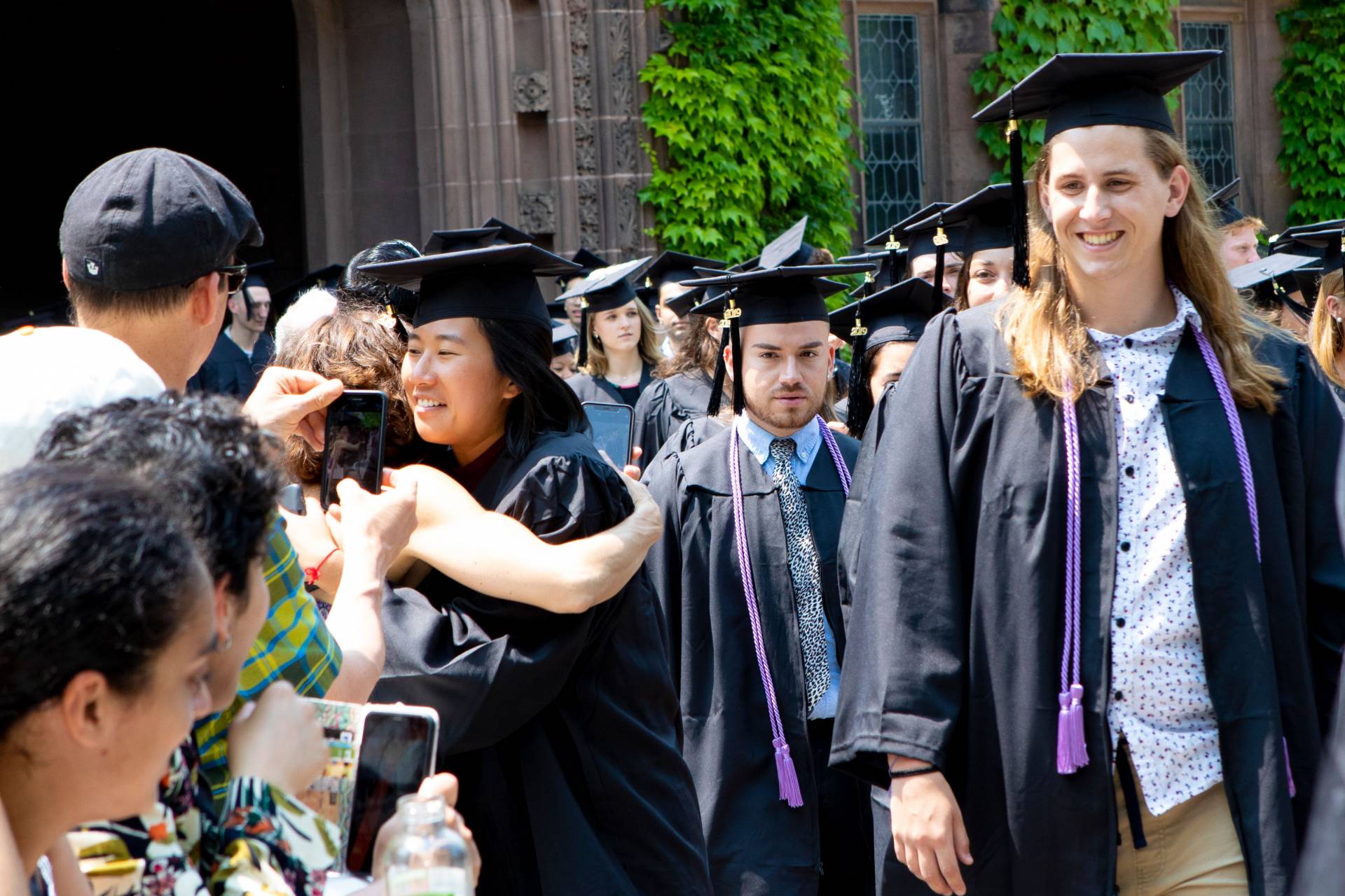 Students process past families cheering them on and hugging them